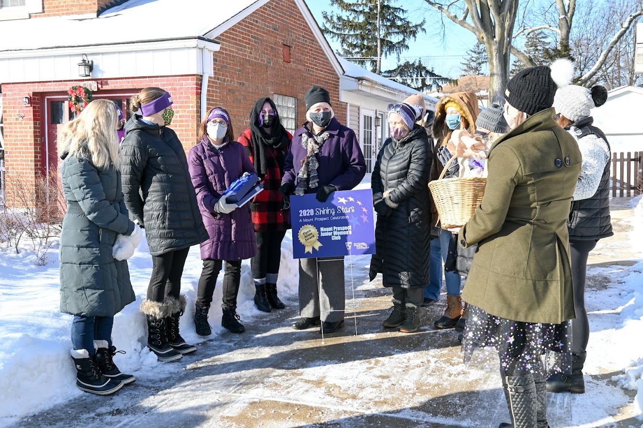 A diverse group of people stands in the snow